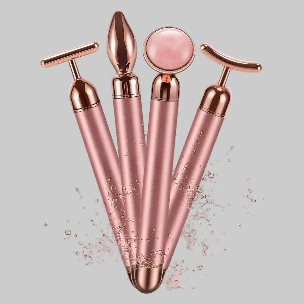 Set of rose gold facial massagers on a pink background
