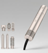 Folding hair comb with interchangeable nozzles on a gray background
