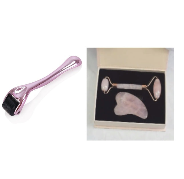 Beauty tool set with pink roller, rose quartz stone, and roller in a box on a white background