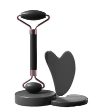 Facial roller and gua sha tool with packaging on a dark background