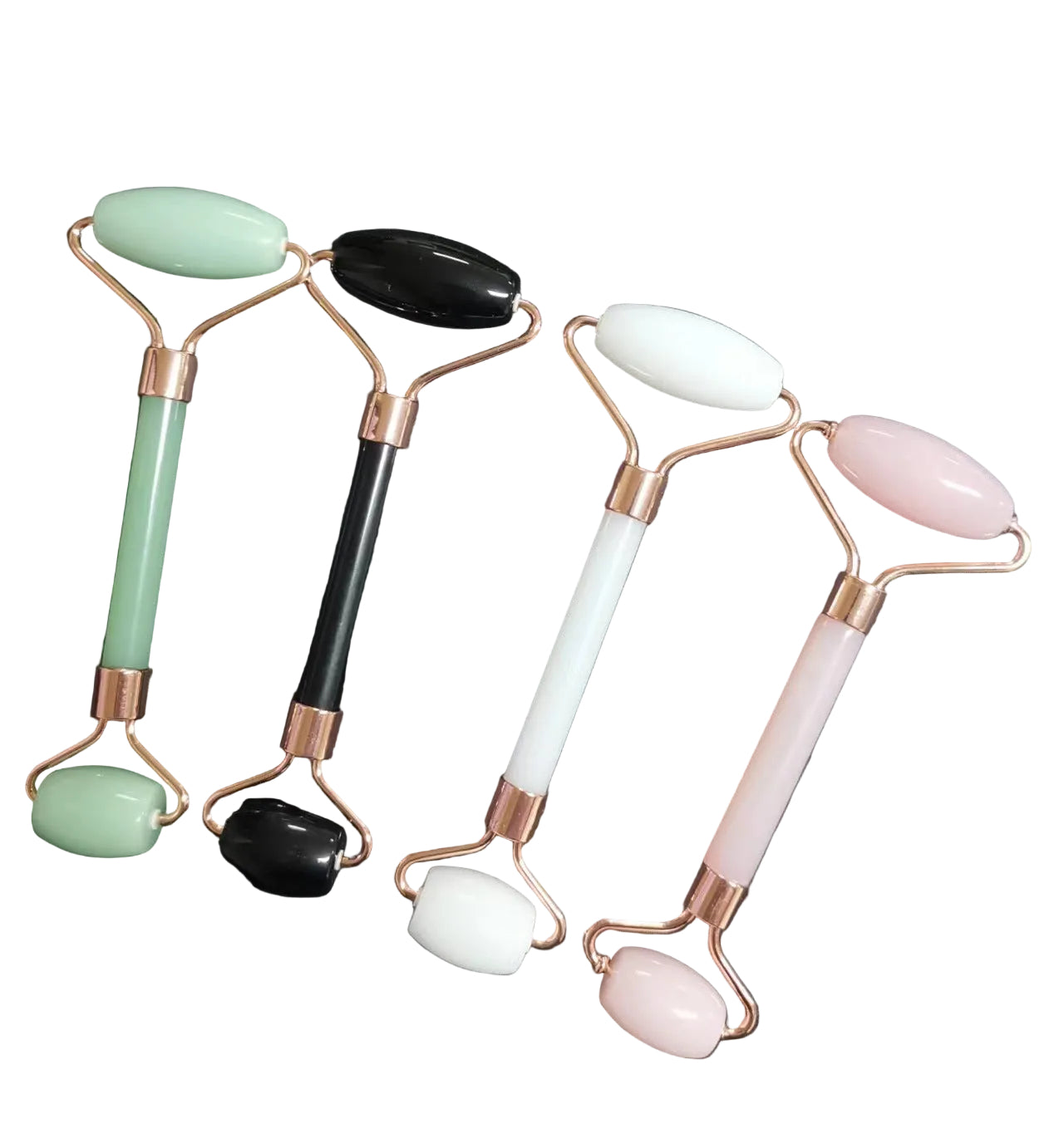 Four facial rollers with different colored stones on a dark background