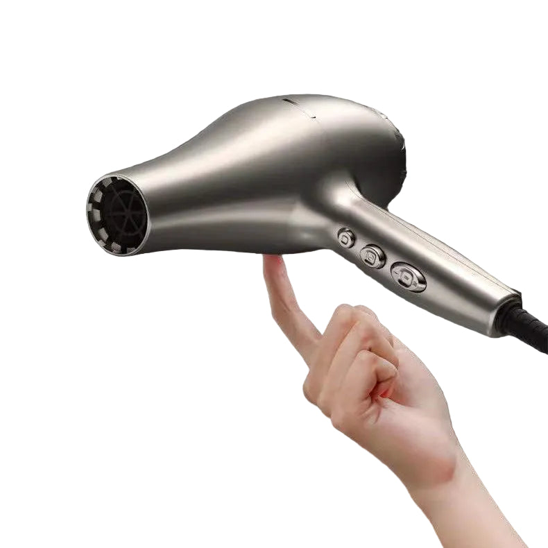 Hand holding a silver hair dryer against a dark background