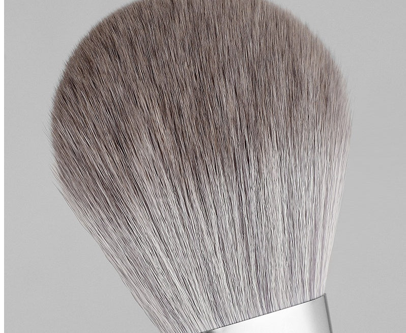 Makeup brush with gray bristles on a light gray background