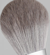 Makeup brush with gray bristles on a light gray background