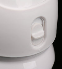 Close-up of a white ceramic teapot with a handle on a black background