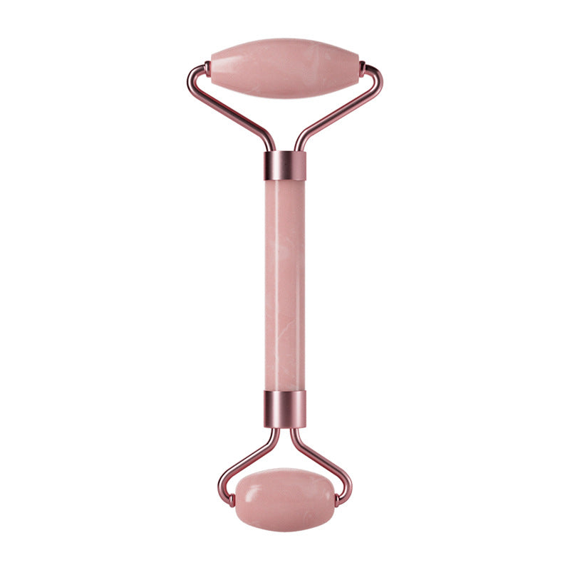 Pink facial roller with rose gold accents on a white background