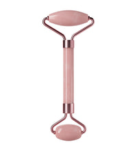 Pink facial roller with rose gold accents on a white background