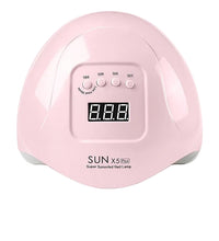 Pink nail lamp with digital display and American plug adapter on a white background