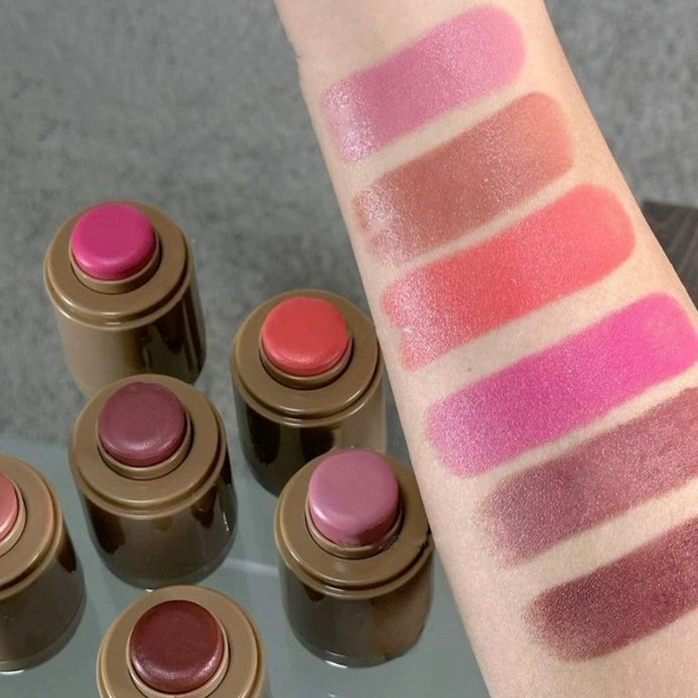 Set of lipsticks with swatches on a arm against a neutral background