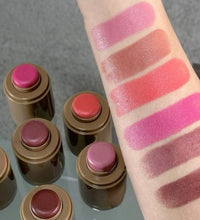 Set of lipsticks with swatches on a arm against a neutral background