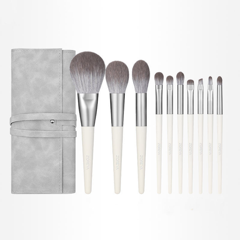Set of makeup brushes with a gray case on a white background