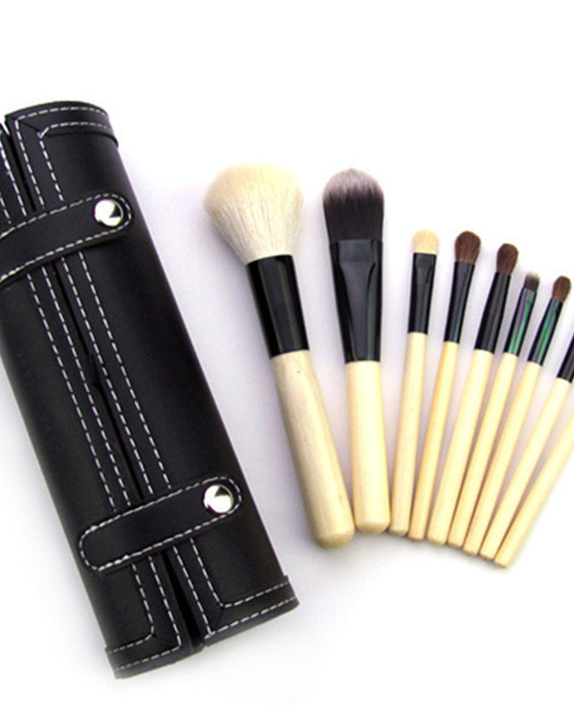 Set of makeup brushes with a black leather holder on a white background