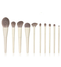 Set of makeup brushes with wooden handles and natural hair bristles on a white background.