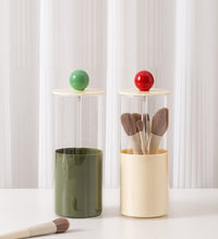 Two cylindrical containers with colorful tops on a white surface.