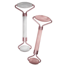 Two facial rollers with jade and pink handles on a textured surface
