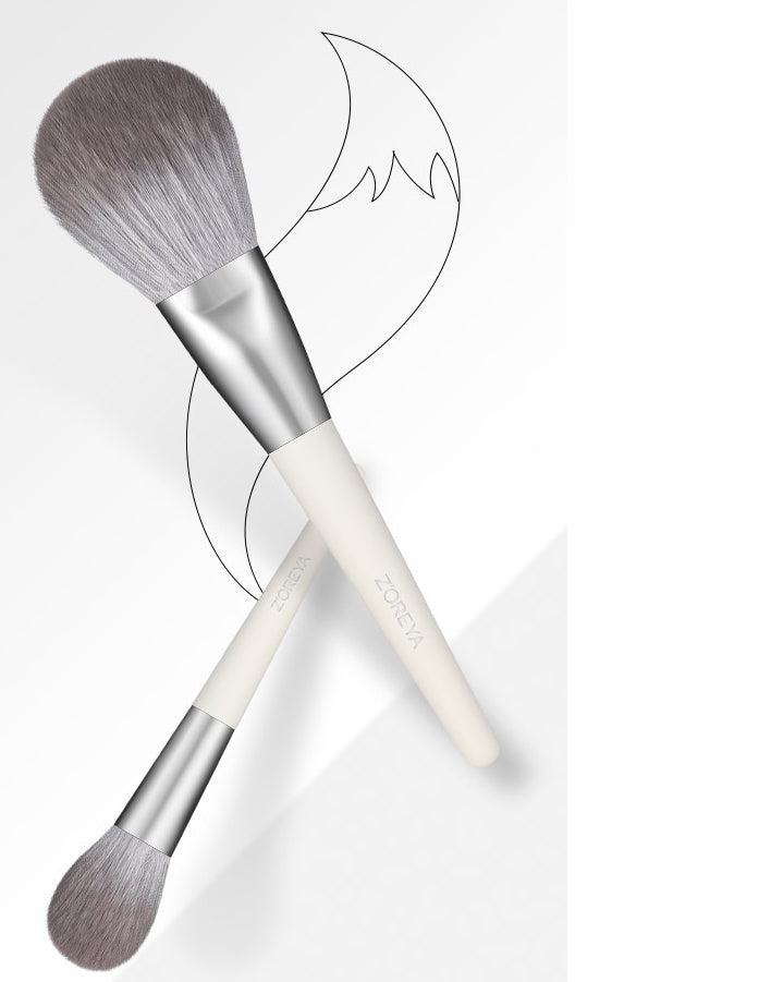 Two makeup brushes with gray bristles on a white background