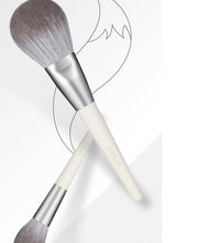 Two makeup brushes with gray bristles on a white background
