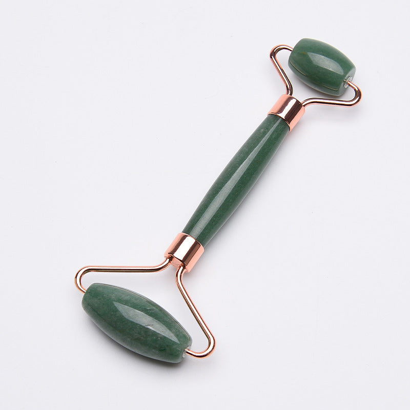Green jade roller with rose gold accents on a white background