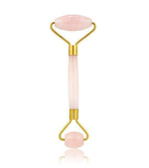 Facial roller with pink stones on a white background