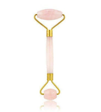 Facial roller with pink stones on a white background