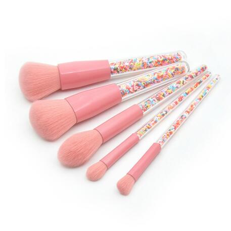 Set of pink makeup brushes with colorful handles on a white background
