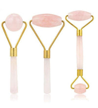 Three facial roller tools with pink stones on a white background