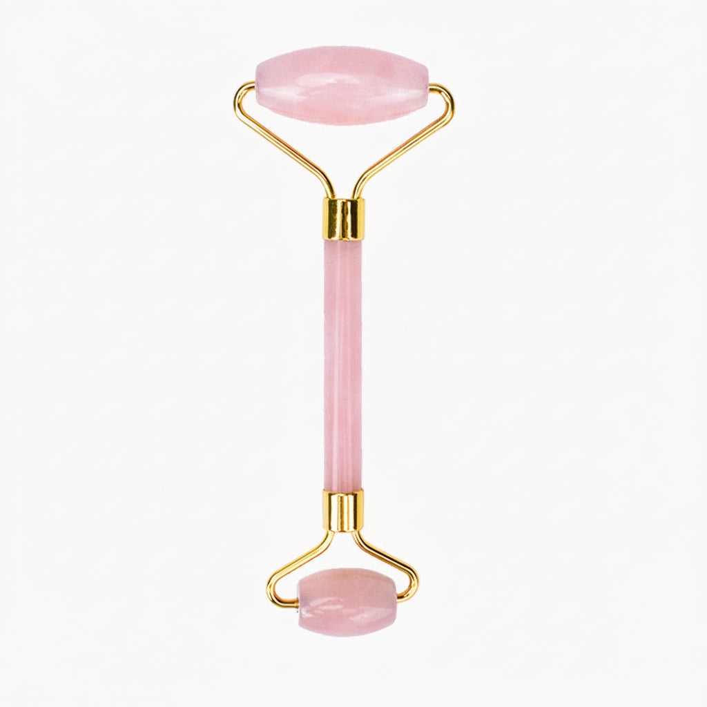 Pink facial roller with gold accents on a white background