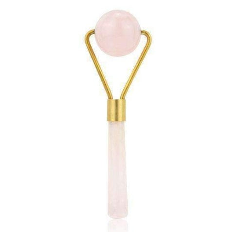 Facial roller with pink stone and gold handle on a white background