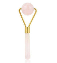 Facial roller with pink stone and gold handle on a white background