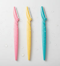 Three colorful eyebrow razors with close-up images of eyes with well-groomed eyebrows.