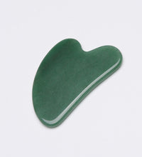 Green stone tool on a light gray background