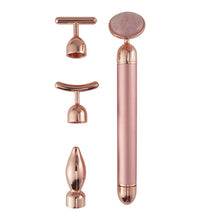 Rose gold facial massager with multiple attachments on a white background
