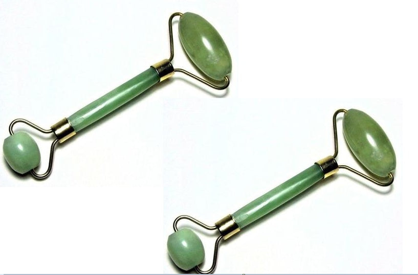 Two green jade rollers on a white background