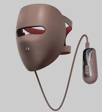 Brown LED face mask with remote control on a white background