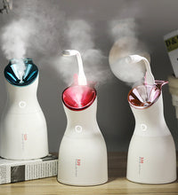 Three small humidifiers emitting steam on a wooden surface with a blurred background.