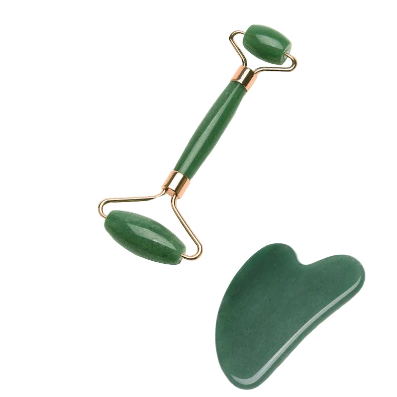 Green facial roller and gua sha tool on a light green platform with a decorative background.