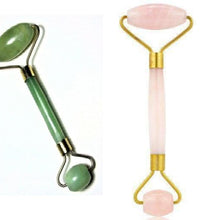 Two facial rollers, one green and one pink with gold accents, on a white background.