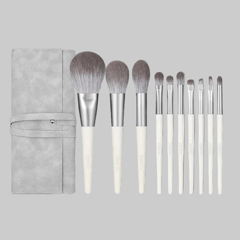 Set of makeup brushes with a gray case on a white background