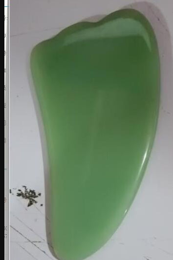 Green plastic object on a white surface
