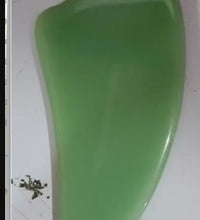 Green plastic object on a white surface