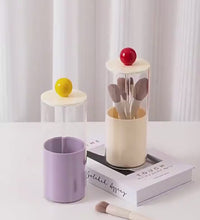 Makeup brush set in a cylindrical glass holder 