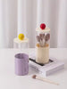 Makeup brush set in a cylindrical glass holder 