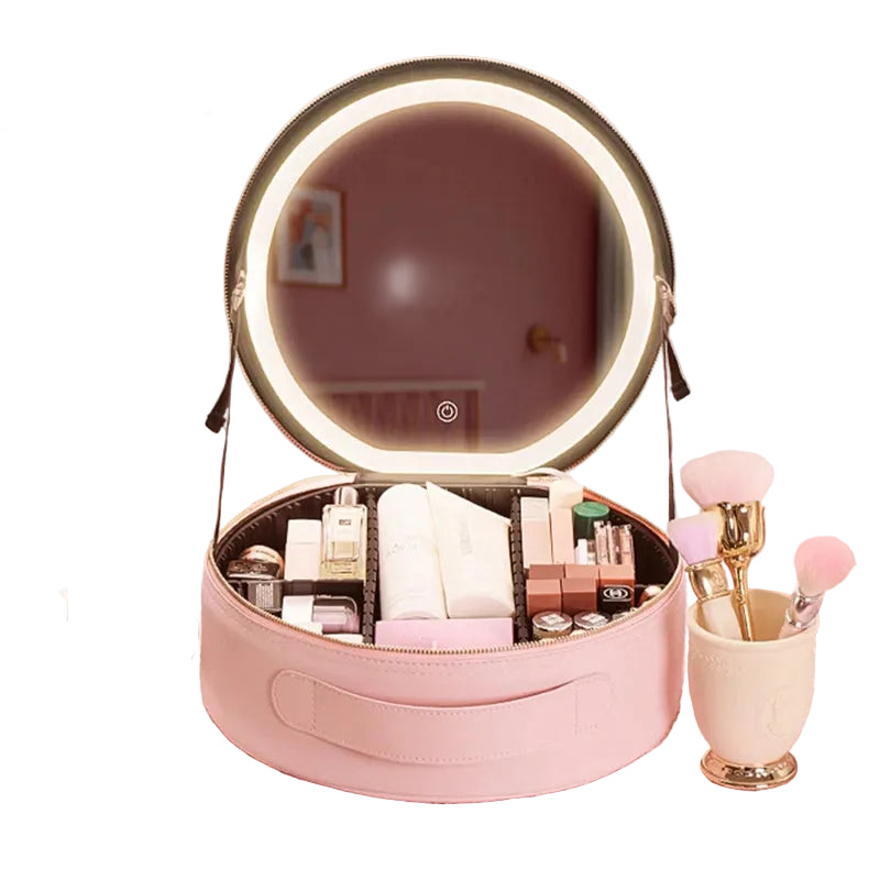 Pink travel vanity case set up on a desk next to makeup brushes and skincare