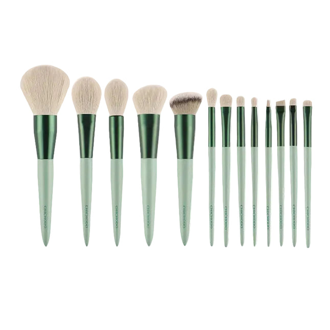 Set of 15 makeup brushes with green handles on a white background