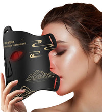 Woman holding a black face mask with red lights and gold designs against a dark background