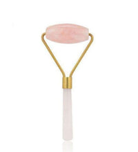 Beauty roller with pink stone and gold accents on a white background