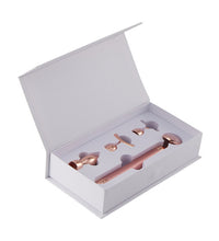 Rose gold ice cream scoop set in a white box on a white background