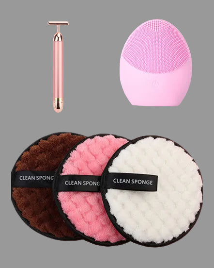 Set of cleaning sponges with a pink facial cleansing brush on a white background