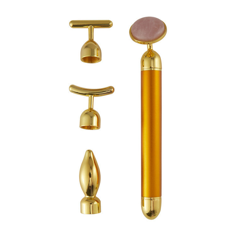 Gold facial roller with multiple attachments on a white background
