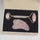 Rose quartz roller and gua sha tool in a black box on a white background